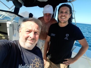 Ninni Ravazza, Stefano Carletti e Andrea Murdock Alpini in barca; sullo sfondo il monte Monaco