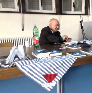 Giarre, 2008, Nunzio Di Francesco incontra gli studenti. Sul tavolo il suo fazzoletto con il triangolo rosso riservato ai prigionieri politici nei lager