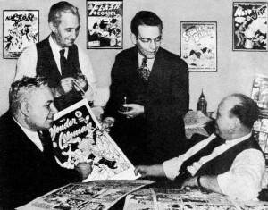 William Moulton Marston e Harry G. Peter insieme all’editor Sheldon Mayer (1917-1991) e all’editore Max Gaines (1894-1947) in una foto del 1942. Davanti a loro le tavole di Wonder Woman