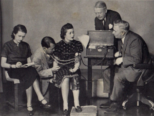 Olive Byrne, Elizabeth Holloway Marston e William Moulton Marston dimostrano il funzionamento della Macchina della Verità ideata da quest’ultimo. Da notare il braccialetto indossato dalla Byrne, simile a quelli di Wonder Woman. Foto del 1938