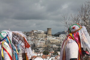 Alcune maschere della Vacca sfilano sul Belvedere a Carnevale. Sullo sfondo, il centro storico del paese. Tricarico (MT), marzo 2022(p, foto di Emanuele Di Paolo.