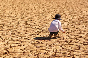 Child Playing on Dry Parched Desert Land